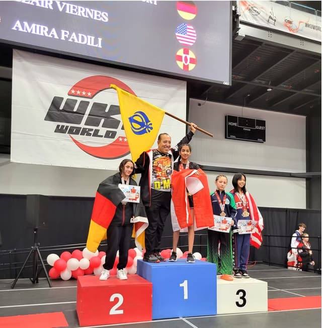DMA athlete on the winner's podium waving a flag