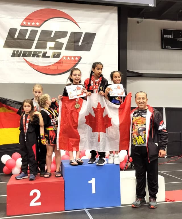 DMA students on the WKU World podium draped in the Canadian flag