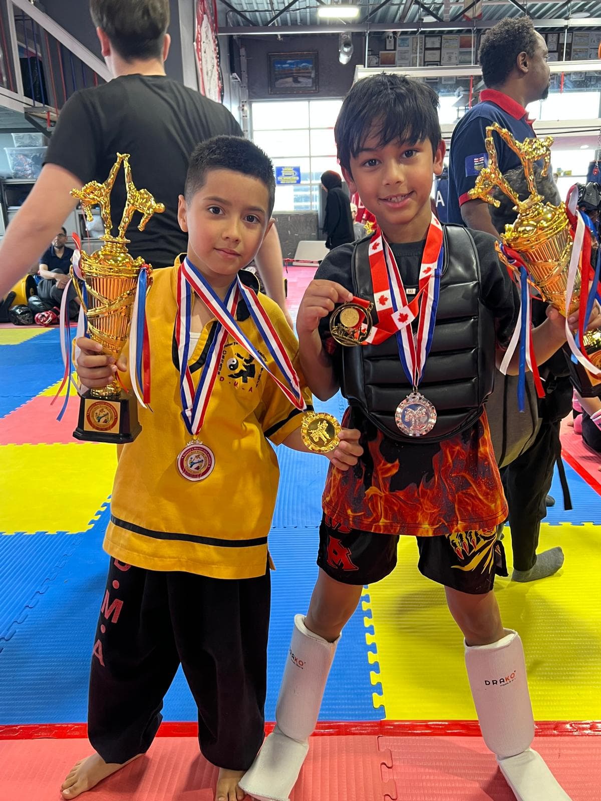 Two young DMA champions holding trophies and medals